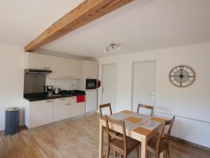 cocina y comedor con mesa y sillas en Appartement T2 40m2 avec extérieur 4 couchages, en Saint-Bonnet-en-Champsaur