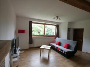 a living room with a couch and a window at Appartement T2 40m2 avec extérieur 4 couchages in Saint-Bonnet-en-Champsaur +3 photos