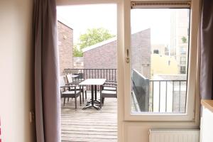 a dining room table with a window overlooking a city at HOLT Hotel in Nijmegen
