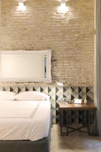 1 dormitorio con 1 cama y 1 mesa con mesita de noche en Architecture & Design Home in Triana, en Sevilla