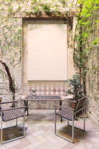 una mesa y dos bancos frente a una pared en Architecture & Design Home in Triana, en Sevilla