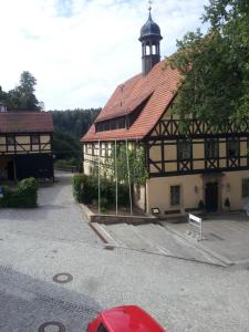 ein Gebäude mit einem Uhrturm darüber in der Unterkunft Gesundheitshaus Hohnstein in Hohnstein