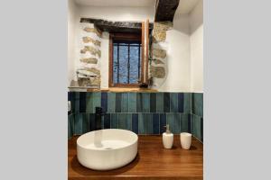 baño con una gran bañera blanca en el suelo de madera en Confortable studio à Mons, au calme absolut, en Mons