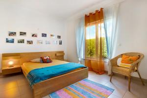 a bedroom with a bed and a window and a chair at Villa Carrapateira in Carrapateira