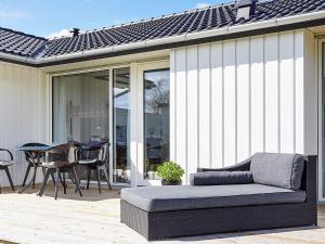 a couch sitting on a patio with a table at 7 person holiday home in Slagelse in Slagelse