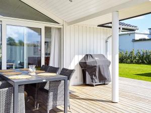 a patio with a table and chairs and a grill at 7 person holiday home in Slagelse in Slagelse