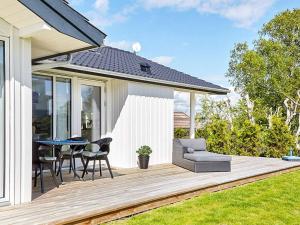 a wooden deck with a table and chairs on a house at 7 person holiday home in Slagelse in Slagelse