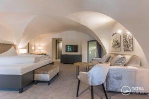 um quarto de hotel com uma cama e um sofá em TATRA SUITES Boutique Suites Deforte Secret Chamber em Poprad
