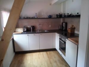 a kitchen with white cabinets and a sink at Gesundheitshaus Hohnstein in Hohnstein