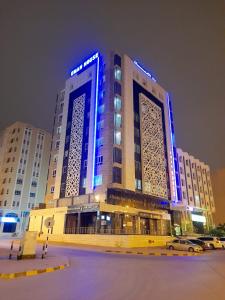 un grande edificio con luci blu sopra di esso di EMAN HOUSE a Salalah