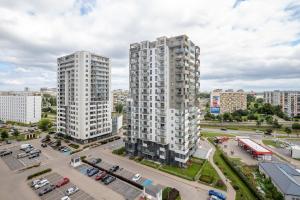 two tall white buildings in a city with a parking lot at Albatross Towers Przymorze Apartments by Noclegi Renters in Gdańsk +20 photos