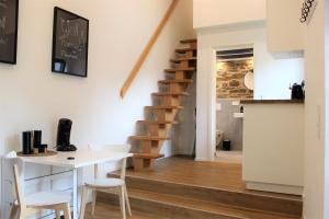 cocina y sala de estar con escalera, mesa y sillas en Ferienapartment Rebwinkel, en Burgen