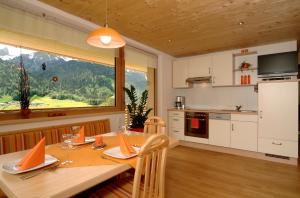a kitchen and dining room with a table and a window at SunAlpin - Ferienwohnungen in Schoppernau