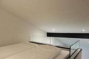 1 dormitorio con 1 cama con pared de cristal en Ferienapartment Rebwinkel, en Burgen