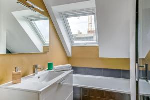 La salle de bains est pourvue d'un lavabo et d'un miroir. dans l'établissement NYMPHÉA - Duplex Hauts Pavés, à Nantes