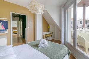 a bedroom with a bed and a large window at NYMPHÉA - Duplex Hauts Pavés in Nantes