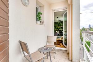eine Terrasse mit 2 Stühlen und einem Tisch auf dem Balkon in der Unterkunft NYMPHÉA - Duplex Hauts Pavés in Nantes