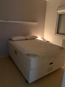 a large white bed in a room with a window at Andy Apto Menino Deus/Cidade Baixa/Orla in Porto Alegre
