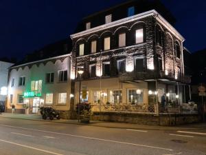 ein beleuchtetes Gebäude in der Nacht auf einer Straße in der Unterkunft Hotel "Zur schönen Aussicht" in Cochem