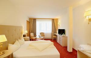 a hotel room with a bed and a living room at Das Schlössl in Haiming