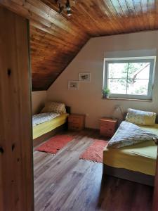 1 dormitorio con 2 camas y ventana en Katica Ház, en Zánka