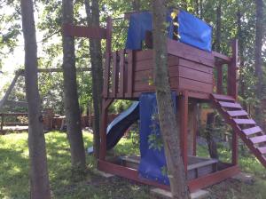 a tree house with a slide in the trees at Blockhaus Harzblick4C in Braunlage