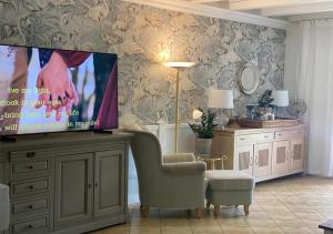 ein Wohnzimmer mit einem Flachbild-TV auf einer Kommode in der Unterkunft Rowy Luxury in Rowy