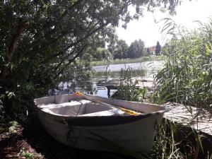 格但斯克新莊園的住宿－Mała Baza Stobna 5，坐在树旁的草上的小船