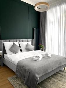 1 dormitorio con 1 cama grande y pared verde en Starowiślna 41-43 by PI Apartments en Cracovia