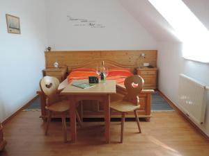 a bedroom with a table and chairs and a bed at Weingut Gästezimmer Gruber in Ehrenhausen