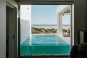 a large swimming pool with a view of the ocean at Graaitjie in Paternoster