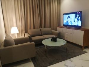 a living room with a couch and a flat screen tv at فندق ايون الندى Ion Hotel in Riyadh