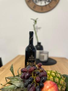 uma garrafa de vinho e um monte de fruta numa mesa em Apartment in city center 2 em Split