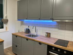 uma cozinha com um lavatório e uma luz azul em Apartment in city center 2 em Split