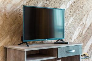a flat screen tv sitting on top of a cabinet at Gradina Holiday in Sozopol