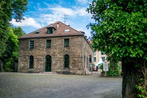 un antiguo edificio de piedra con techo rojo en Hotel Bachmühle, en Fulda