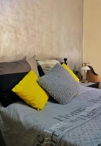 a bed with yellow and black pillows on it at Nice appartement à Marrakech in Marrakesh