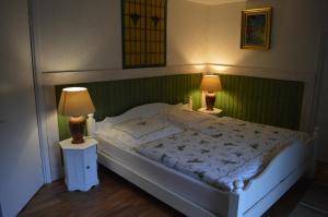 a bedroom with a large white bed with two lamps at Bodasjön in Boda Glasbruk