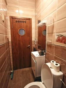 a small bathroom with a toilet and a wooden door at Nice appartement à Marrakech in Marrakesh