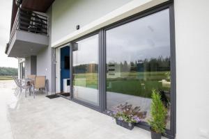 a sliding glass door on a house with a patio at Domki pod Lasem 66 in Trybsz