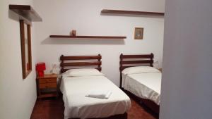 Habitación con 2 camas y sábanas blancas. en ULLASTRES III en Es Mercadal