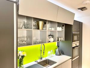 una cocina con armarios verdes y blancos y fregadero en Apartment Twelve en Shrewsbury