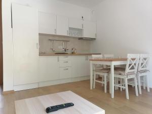 a kitchen with a table and a remote control on the floor at Aparments Kostić in Bajina Bašta