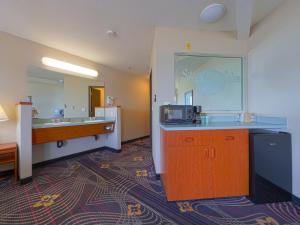 a hotel room with a sink and a microwave at Siletz Bay Beachfront Hotel by OYO Lincoln City in Lincoln City
