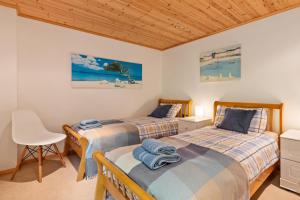 2 bedden in een slaapkamer met een bureau en een stoel bij Lodge 5 Longbury - Luxury Lodge, Golf Course Views, Restaurant and Spa Facilites in Penally