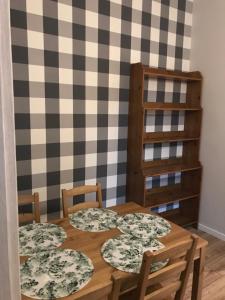 a dining room table with two chairs and a checkered wall at Zaciszny Apartament w Zdroju in Kudowa-Zdrój