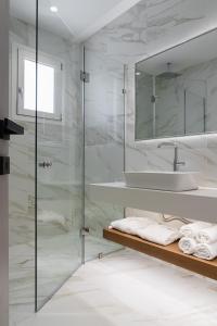 アカラヴィにあるBalia Suitesのバスルーム(ガラス張りのシャワー、シンク付)
