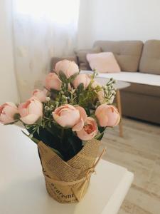 a vase of pink roses sitting on a table at Apartment Jovana in Igalo
