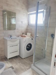 a bathroom with a washing machine and a sink at Apartment Jovana in Igalo