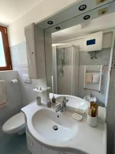 a bathroom with a sink and a toilet and a mirror at Trullo Bianco in Putignano